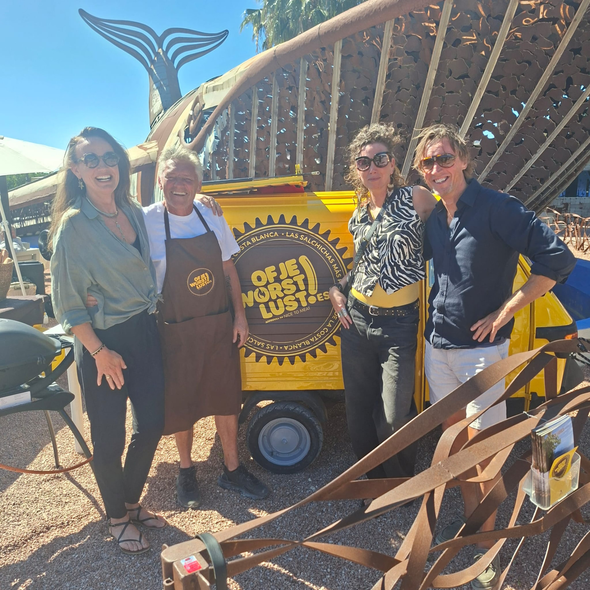 Friends gathered around the yellow Of je worst lust tuk-tuk in the sunshine